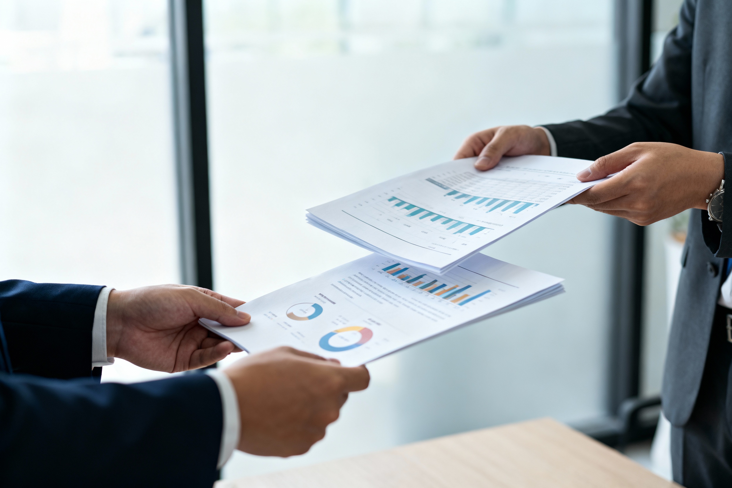 Деловая встреча в современном офисе, руки игроков обмениваются документами и финансовыми бумагами, мягкое естественное освещение